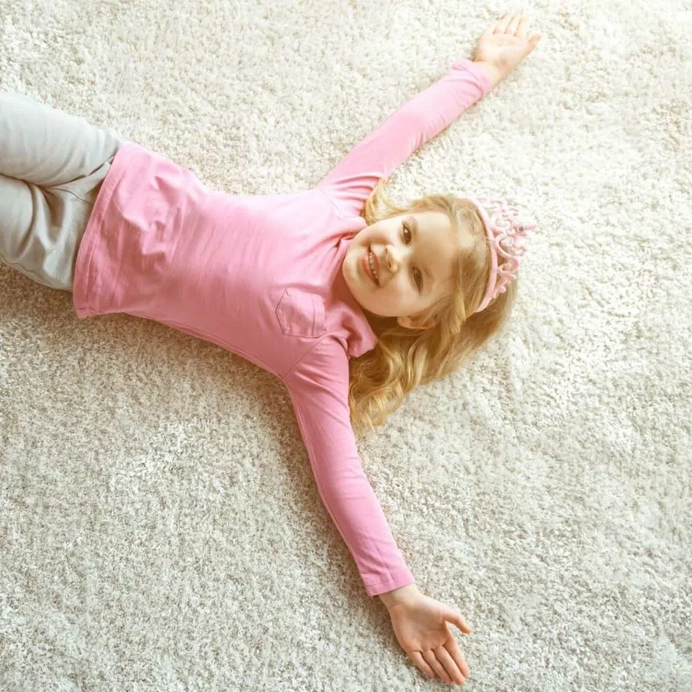 Cute baby girl laying on soft rug